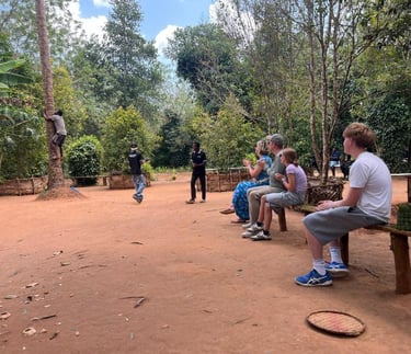 Visitor watching a coconut climber demonstrate traditional coconut harvesting during a luxury Zanzibar spice farm