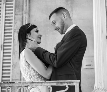 a bride and groom standing on a balcony railing