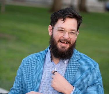 a bearded bearded man in a blue suit and tie
