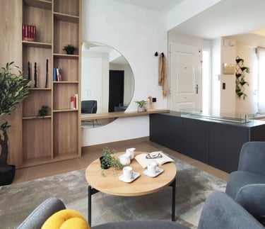 Decoración de interiores de zona relax con librería de madera, chimenea de bioetanol y butaca en San Antonio de Benaguér