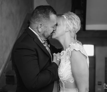 a bride and groom kissing on the stairs of a staircase