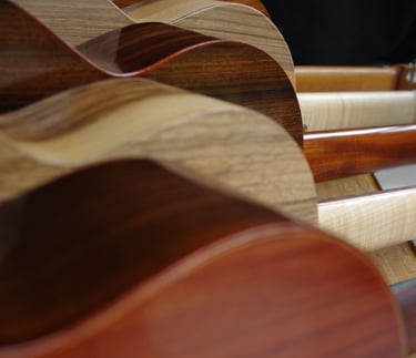 Close-up view of handcrafted wooden guitars master grade tonewoods and headstocks.