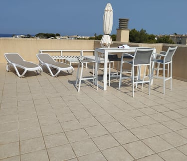 a patio with a table and chairs and umbrellas