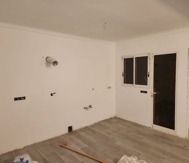 a room with a lot of white walls and a window