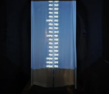 A curtain separating the corridor with the first artwork. The names shown are those of the victims
