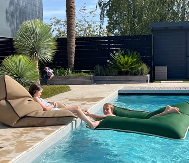 Coussins Biboo sur transats autour d’une piscine dans un hôtel de plein air