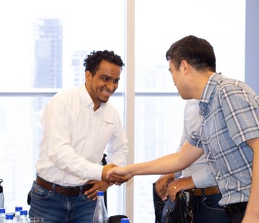 a man shaking hands with another man in a room