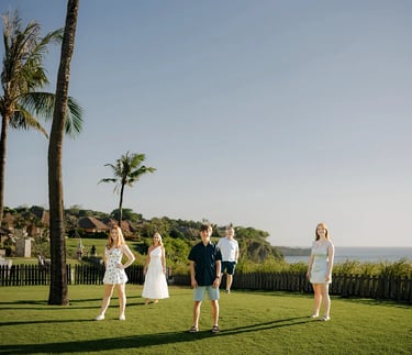 Family portrait on the oceanfront lawn during a family photography session at AYANA Resort Bali