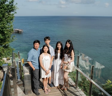Family standing together overlooking the ocean during a relaxed photography session at Ayana Jimbaran Bali