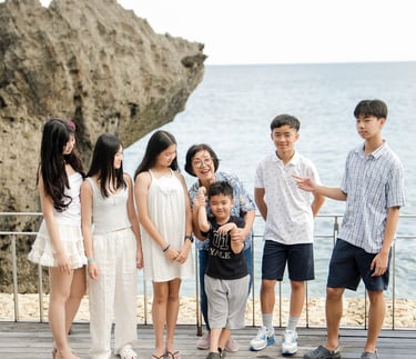 Extended family standing together by the ocean during a natural lifestyle photography session at Ayana Jimbaran Bali