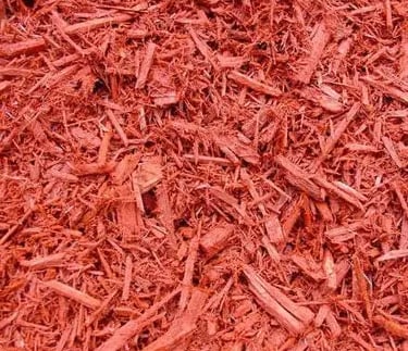 Close-up of vibrant red dyed wood mulch chips for professional landscaping and garden ground cover.
