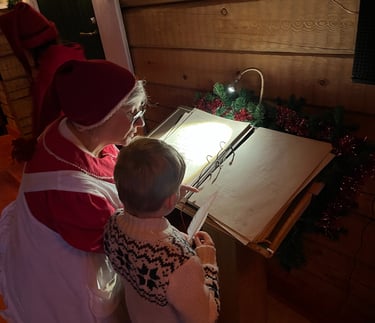 Mrs Claus helping a boy to write a message