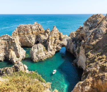 a boat in the water near a cliff