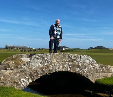 a man standing on a stone bridge over a stream