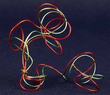 Abstract metal wire sculpture of a person kicking a soccer ball