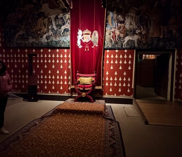 a red chair against a red tapestry and walls