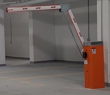 Automatic folding arm barrier gate installed in an underground parking garage for access control.