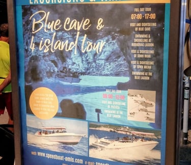 The picture shows a billboard advertising a one-day boat visit to the Blue Cave on the island of Biševo.