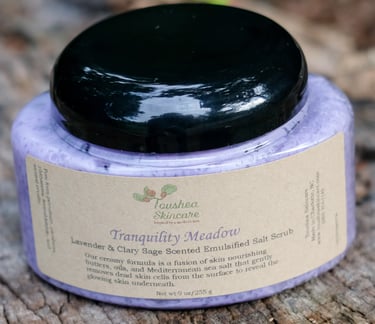 jar of lavender colored sea salt scrub on a tree stump