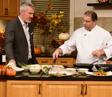 two men in suits and ties standing in a kitchen