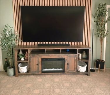 Living room featuring a flat screen TV mounted on a wood slat accent wall above a rustic fireplace media console.