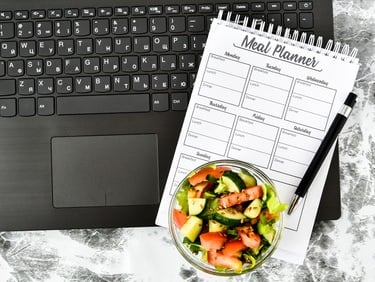 a notebook with a salad on a marble table