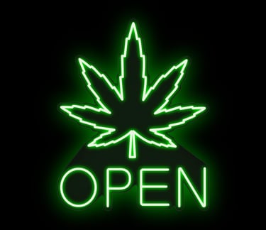 Dispensary storefront at night with open sign