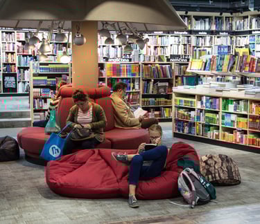 a woman sitting on a couch in a library
