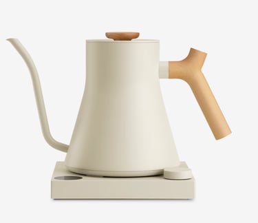 Cream-colored electric gooseneck kettle with a wooden handle on a matching minimalist heating base.
