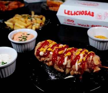 a corndog on a plate with ketchup and ketchup