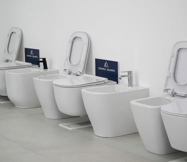 Modern wall-hung Ceramica Dolomite toilets and bidets on display in a white bathroom showroom.