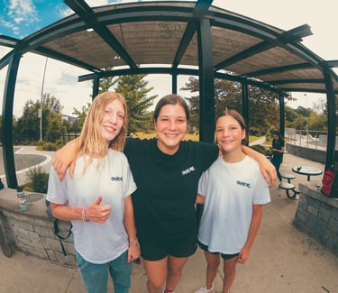 three girls hugging ad smiling