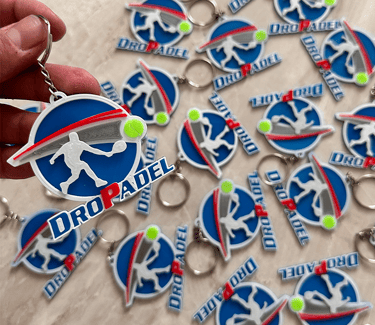  3d llaveros posadas Dropadel featuring a blue circular logo with a padel player silhouette.