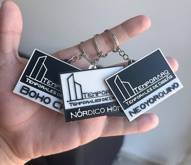 Custom 3D printed keychains for Temporarq architectural design styles held in hand.