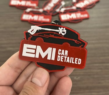  3d llaveros apóstoles EMI Car Detailed held in hand, featuring a pressure washer logo.