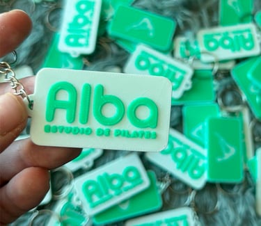Custom green and white 3D printed  3d llaveros apostoles for Alba Studio de Pilates branding.
