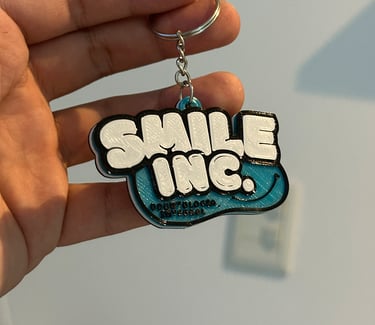 Custom 3D printed Smile Odontologia 3d llaveros posadas in teal and white with graffiti style text.