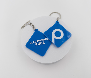 Custom blue 3D printed  3d llaveros posadaswith Electronica Piriz logo on a white display stand.