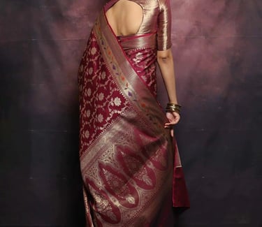 Woman wearing an elegant maroon Banarasi silk saree with intricate gold floral zari embroidery.