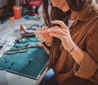 ARTESANA ELABORANDO UNA PULSERA CON CUENTAS 