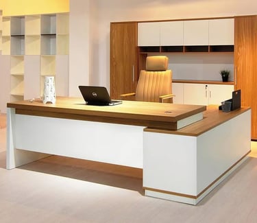 Modern executive L-shaped wooden desk with a laptop and leather chair in a contemporary home office.