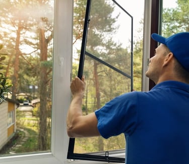a man in a blue shirt is holding a window pane