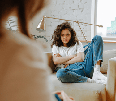 Photo d'une adolescente boudeuse sur un canapé
