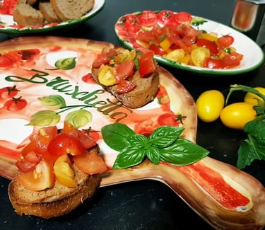 Homemade tomato bruschetta served on a decorative wooden board with fresh basil and yellow cherry tomatoes.