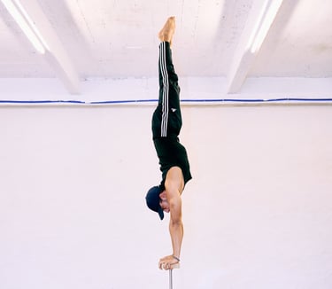 Man voert een rechte handstand uit op canes bij De Polecats Fabriek in Gent