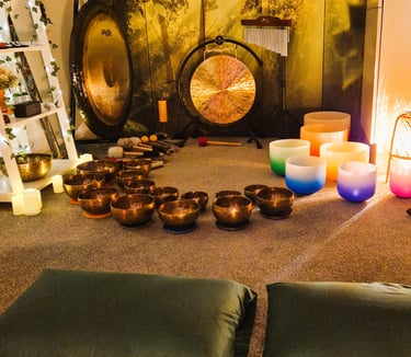 Studio with gongs and singing bowls on the floor in front of two pillows