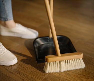 a person standing on a wooden floor with a broom and a broom