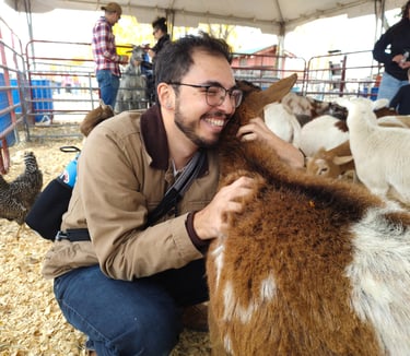 Luis at a petting zoo hugging a goat that took to him very well!