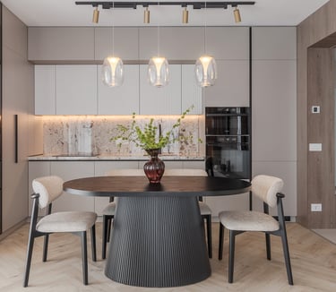 Modern dining room featuring a black round table, stylish chairs, and designer pendant lights in a luxury kitchen.