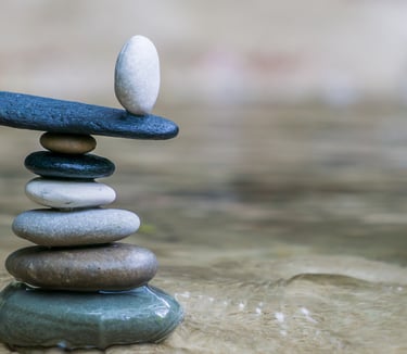 A pile of stones on sand, with one stone on the top balancing